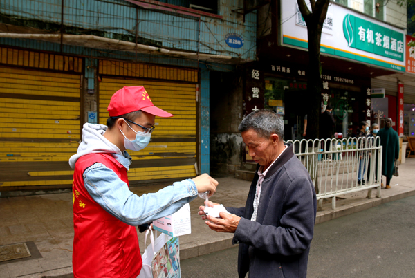 2022年9月13日，納雍縣城，志愿者在向未戴口罩的市民發(fā)放口罩，并要求戴上 。