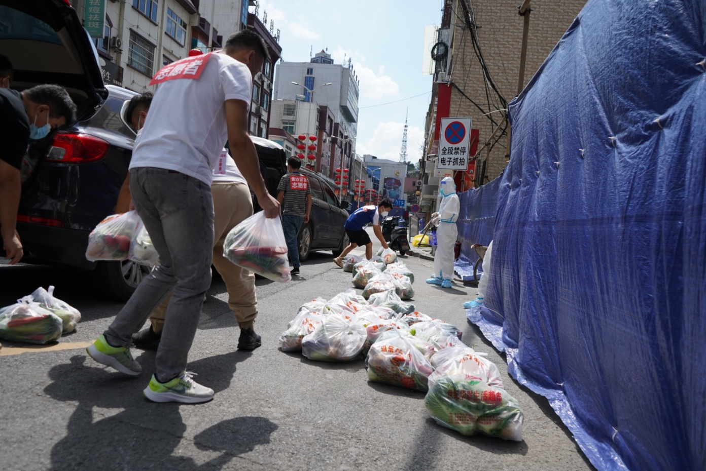 金沙縣鼓場(chǎng)街道的匯金大廈小區(qū)工作人員正在為居民送蔬菜包。