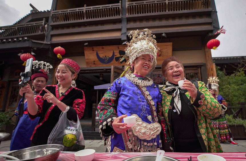 10月31日，游客在丹寨縣萬達(dá)小鎮(zhèn)長桌宴上與苗族同胞同唱祝酒歌。