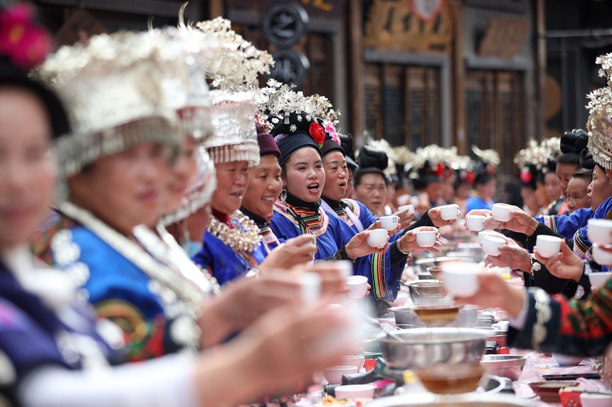 10月31日，在丹寨縣萬達(dá)小鎮(zhèn)，身著節(jié)日盛裝的苗族同胞在長桌宴上唱敬酒歌。