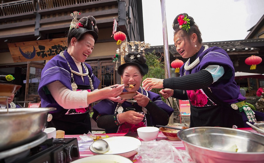 10月31日，在丹寨縣萬(wàn)達(dá)小鎮(zhèn)，身著節(jié)日盛裝的苗族同胞在長(zhǎng)桌宴上敬酒菜。