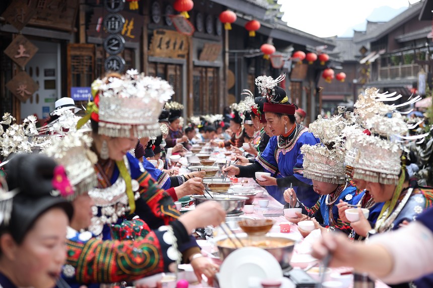 10月31日，在丹寨縣萬達小鎮(zhèn)，身著節(jié)日盛裝的苗族同胞在長桌宴上品嘗美食。 