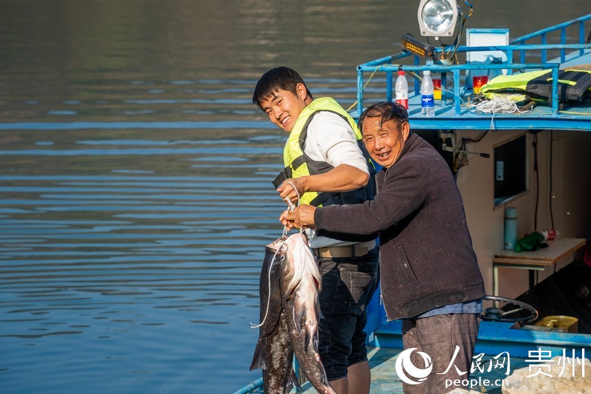 工作人員展示收獲的鳙魚。人民網(wǎng)記者 涂敏攝