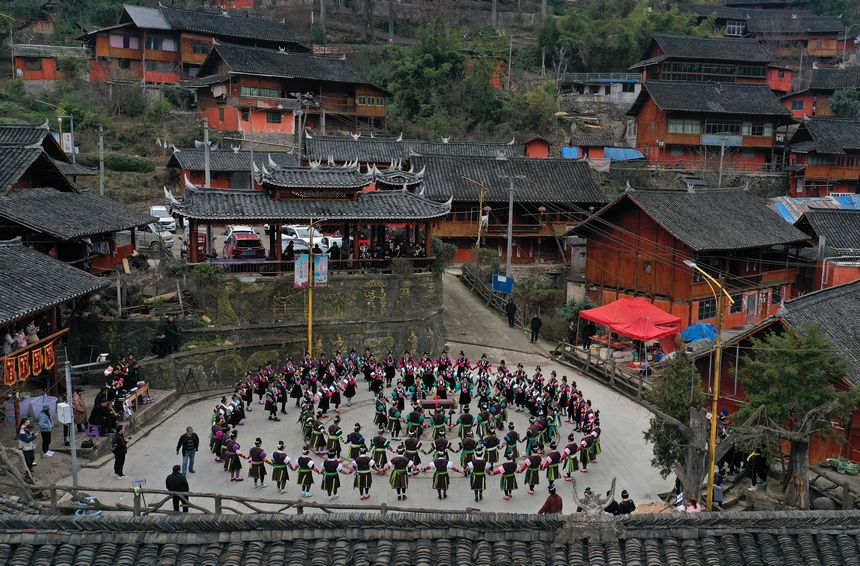 2月24日，貴州省黔東南苗族侗族自治州丹寨縣興仁鎮(zhèn)王家村，身著盛裝的苗族村民在跳鼓場(chǎng)上跳木鼓舞（無人機(jī)照片）。