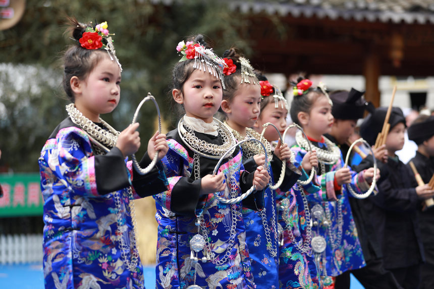 4月22日，新民村當?shù)孛缱搴⒆釉诟哂好缱濉叭氯懊褡逦幕寡萆媳硌莨?jié)目《苗山迎客來》。