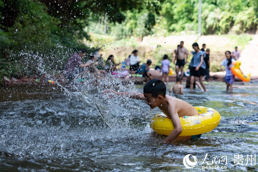 小朋友在瑪瑙灘內(nèi)打水仗。人民網(wǎng)記者 涂敏攝