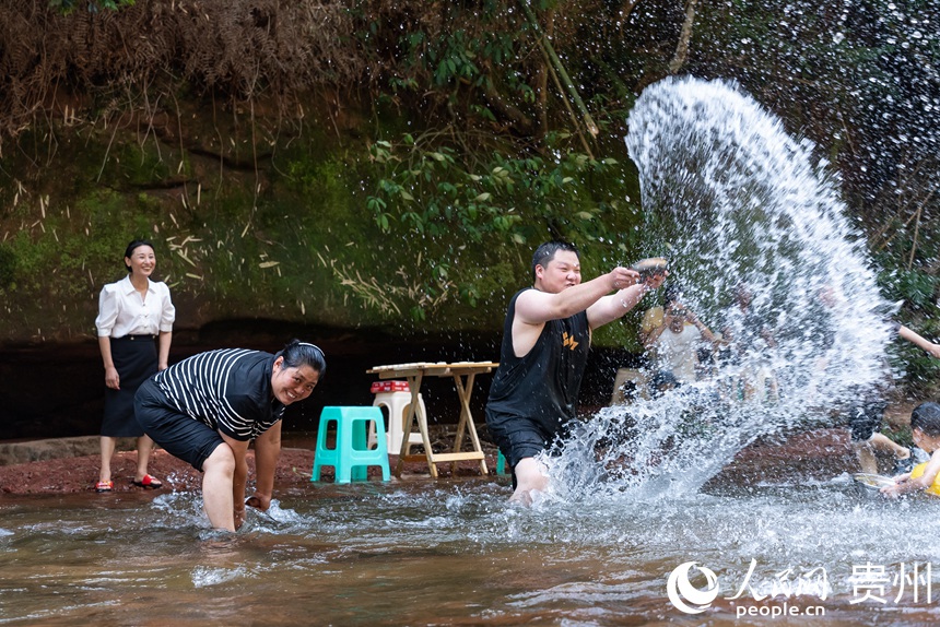 游客在瑪瑙灘內(nèi)打水仗。人民網(wǎng)記者 涂敏攝