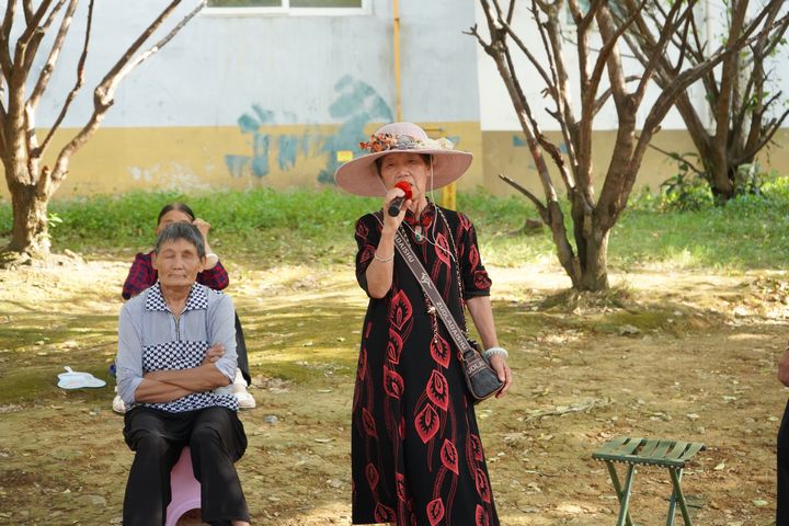 金民社區(qū)的老人在綠蔭下乘涼歡歌。黃源匯攝