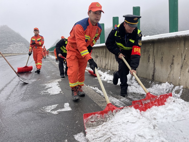 交通執(zhí)法人員與消防人員共同對路面積雪進(jìn)行清除。