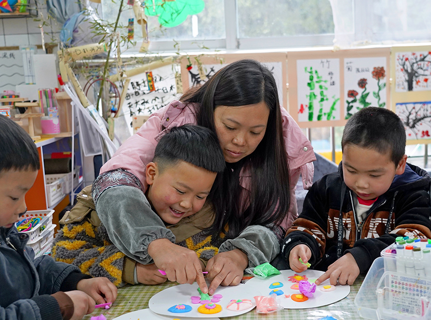 2025年3月6日，貴州省畢節(jié)市納雍縣龍場(chǎng)鎮(zhèn)中心幼兒園“溫情三八·感恩有您”活動(dòng)現(xiàn)場(chǎng)，家長(zhǎng)和孩子們一起做手工。 楊  英 攝