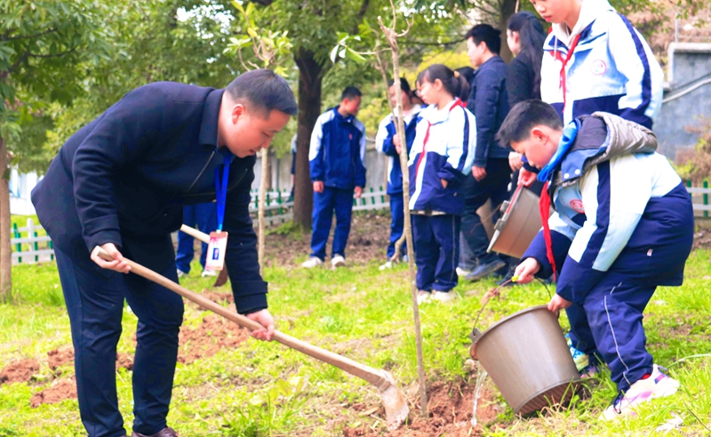 習(xí)水縣第十二中學(xué)教師與學(xué)生配合，澆水培土參與植樹。